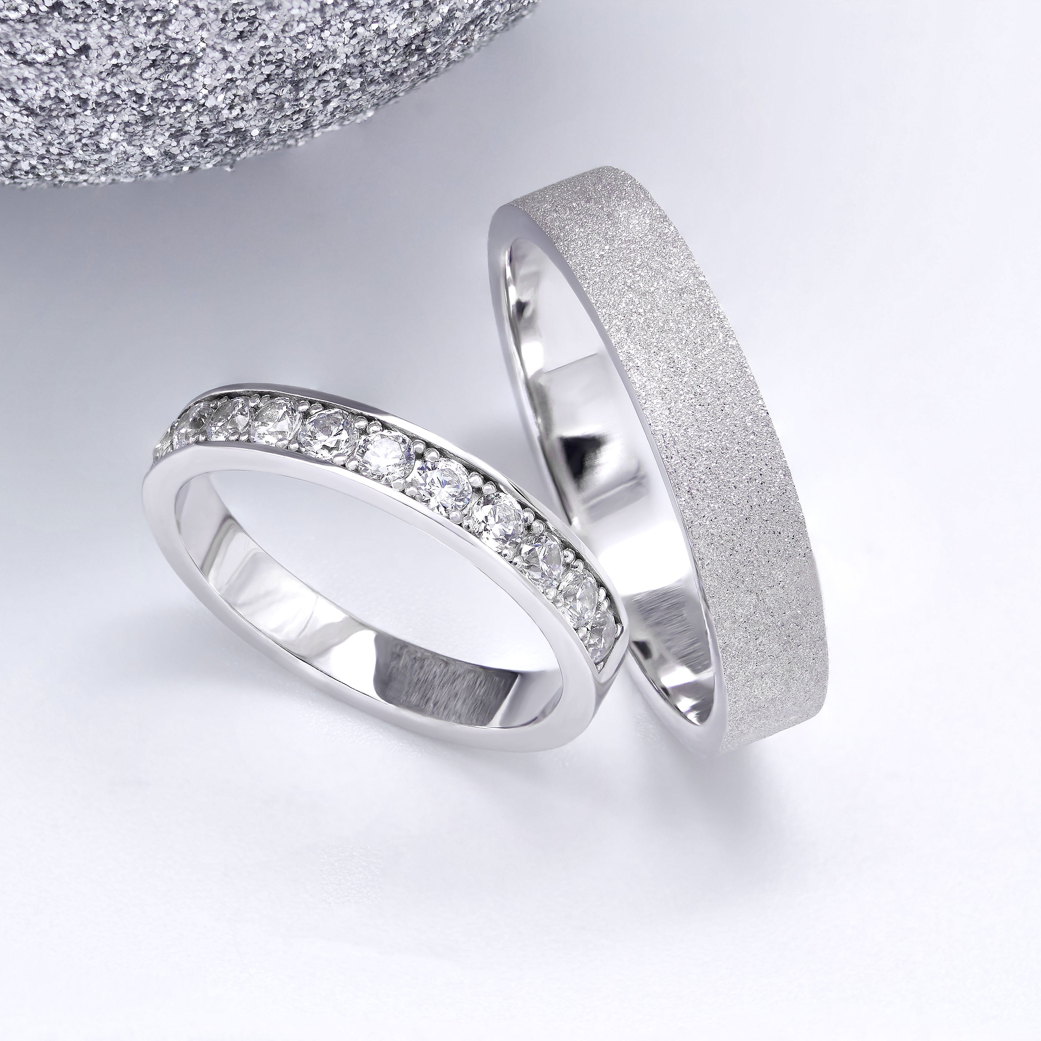 Кольцо невесты инкрустировано 11 бриллиантами 2,25 мм. Кольцо жениха 4,5 мм. Текстура алмазная мелкая.
