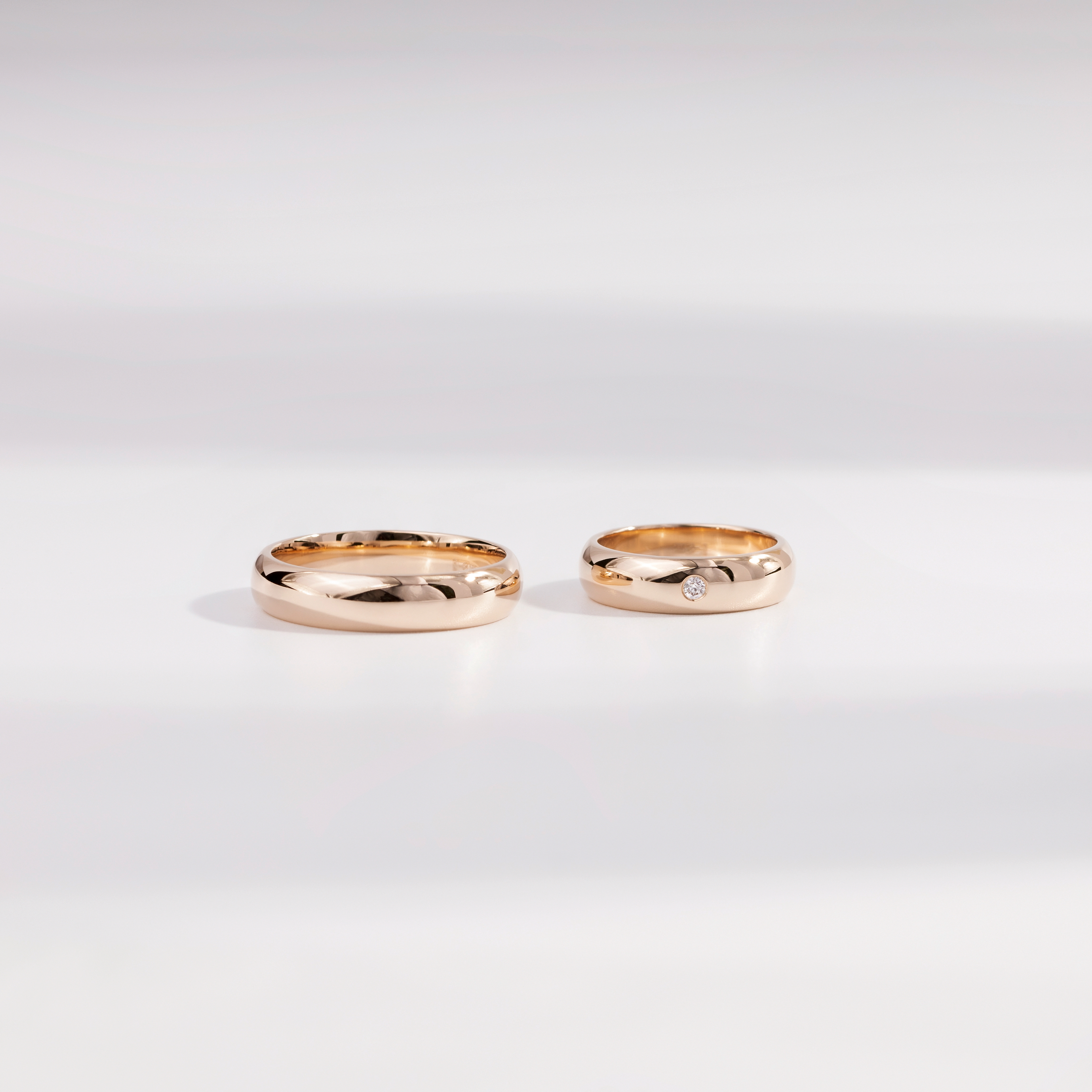 Обручальные кольца из розового золота 585 пробы. Ширина колец по 5 мм. Вставка бриллиант 2 мм, 0,031 карат.